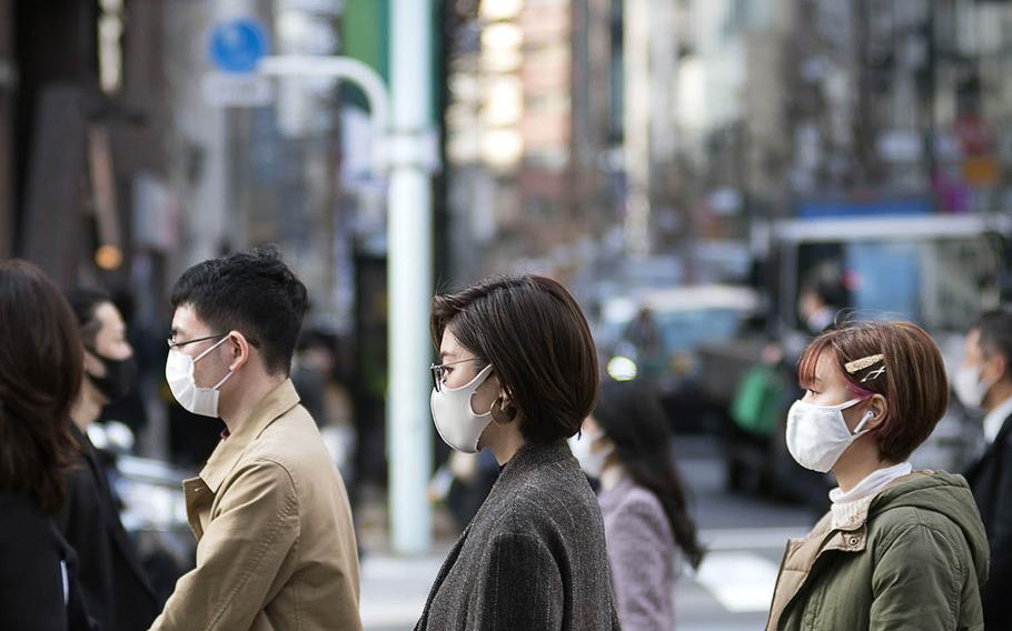Pedestrians wear masks to guard against the coronavirus in the Ginza district of central Tokyo, March 9, 2021.
