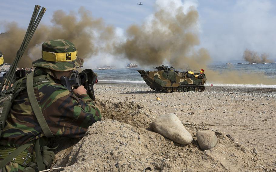 In a March, 2014 photo, Republic of Korea Marines with 7th Marine Regiment, simulated opposition forces, observe as Assault Amphibious Vehicles approach shore during Integrated Amphibious Assault for Ssang Yong 14 at Doksu-ri Beach, Pohang, South Korea. Exercise Ssang Yong is conducted annually in the Republic of Korea (ROK) to enhance interoperability between U.S. and ROK forces.