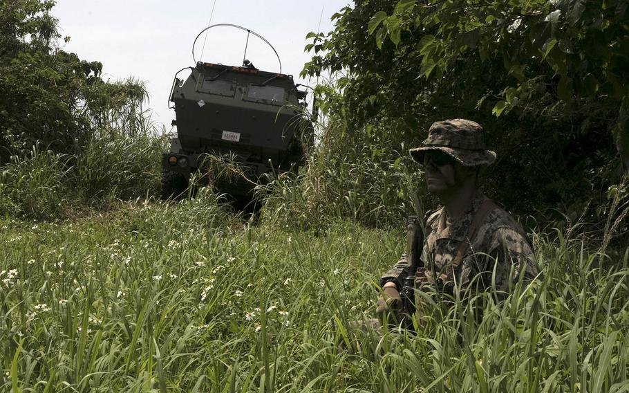 A Marine guards an M142 High Mobility Artillery Rocket System, or HIMARS, during Exercise Castaway on Ie Shima, Okinawa, March 15, 2021.