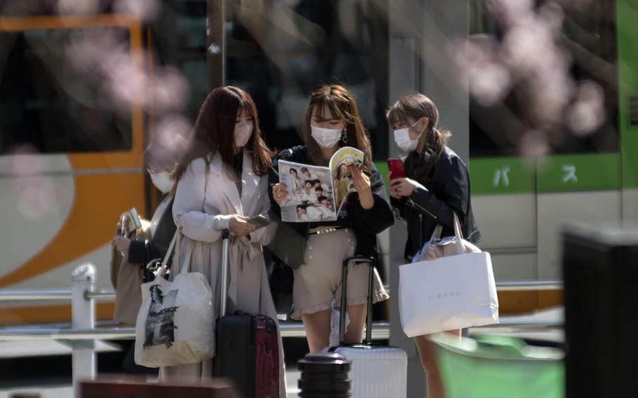 Women wear masks to guard against the coronavirus near Ueno Park in central Tokyo, Wednesday, March 17, 2021. 
