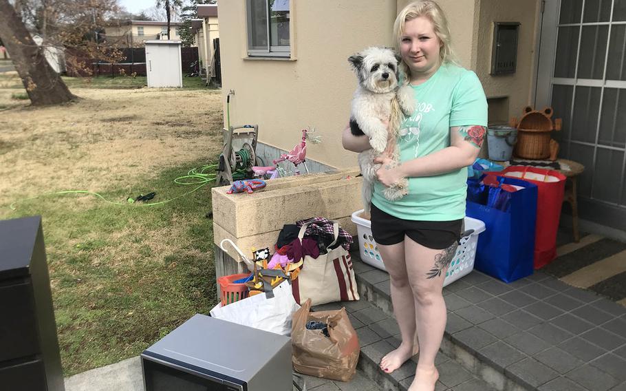 Army spouse Lydia Christy poses with items donated by neighbors just hours after a fire gutted her family's home at Yokota Air Base, Japan, Tuesday, March 23, 2021. 
