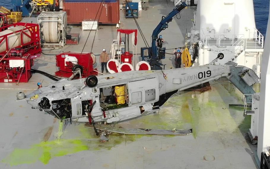 The U.S. Navy Seahawk helicopter lies upside-down on the deck of a salvage ship after being lifted 3.6 miles from the ocean floor near Okinawa on March 18, 2021.