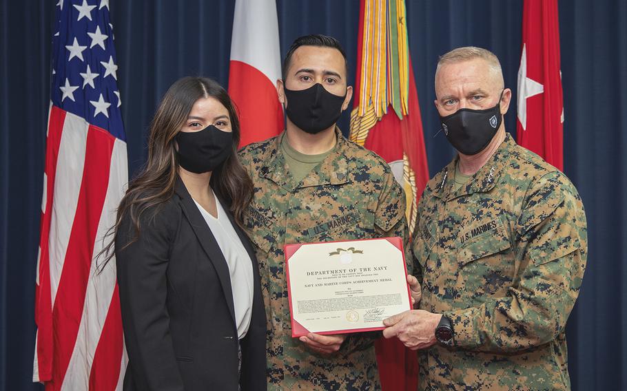 Marine Sgt. Jovany Gutierrez, center, received the Navy and Marine Corps Achievement Medal from III MEF commander Lt. Gen. H. Stacy Clardy on March 12, 2021, for saving an Okinawan woman's life in January. At left is Gutierrez's wife, Nidia Gutierrez.