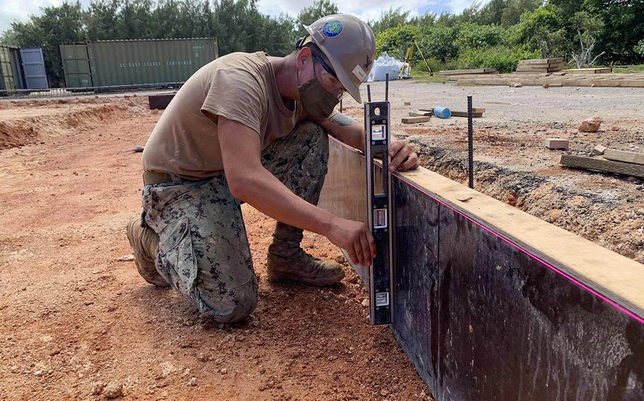 A sailor plumbs a support wall for a construction project at Andersen Air Force Base, Guam, Nov. 11, 2020.