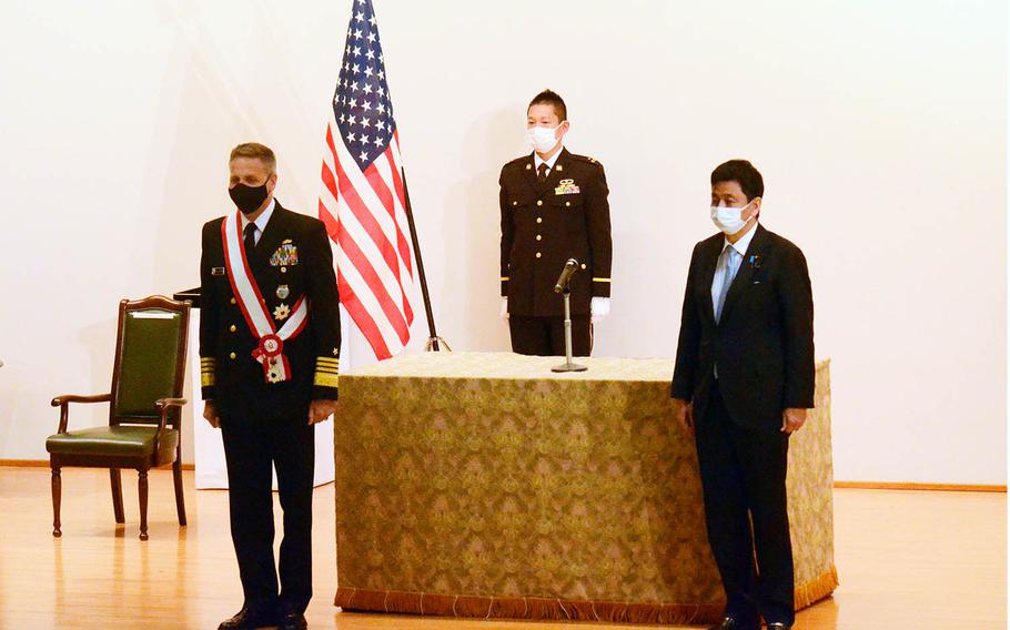 The head of U.S. Indo-Pacific Command, Adm. Philip Davidson, left, receives the Grand Cordon of the Order of the Rising Sun, Japan's third-highest honor, at the Ministry of Defense in Tokyo, Monday, April 12, 2021. 