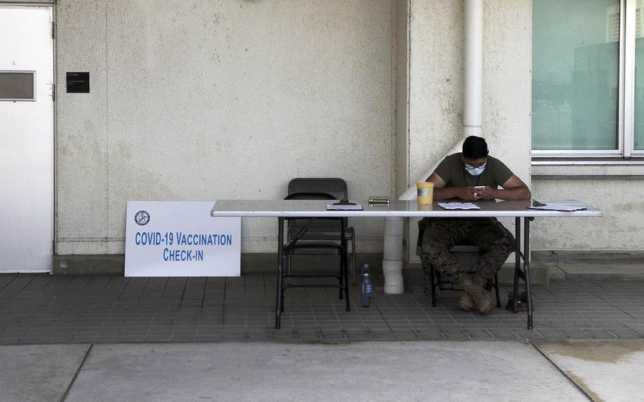 A Navy corpsman takes a break between scheduled coronavirus vaccinations at Naval Hospital Okinawa, Tuesday, April 13, 2021.