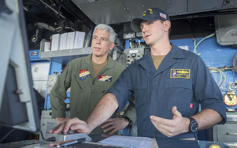Rear Adm. Karl O. Thomas, left, visits the guided-missile cruiser USS Chancellorsville in the Philippine Sea, Nov. 17, 2018. 