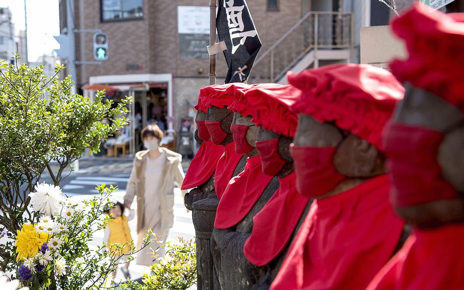 Jizo statues seen near Kamakura, Japan, Sunday, April 18, 2021, are clothed in masks as a petition to the deity that guards women and children to end the coronavirus pandemic soon. 