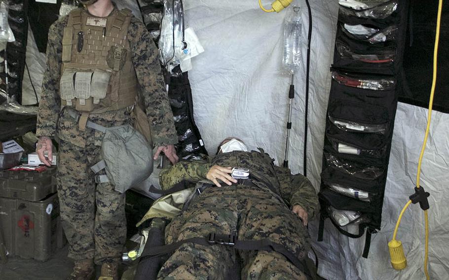 A mock casualty is brought into a medical tent during a 1st Marine Aircraft Wing combat readiness exercise on Ie Shima, Okinawa, April 16, 2021.