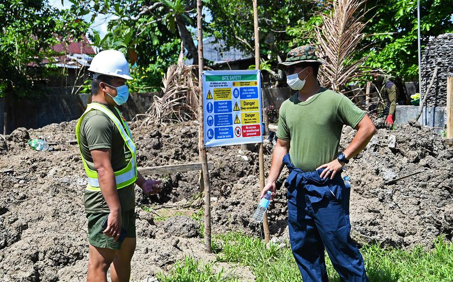 Philippine Army 1st Lt. Celestino Aporado Jr., left, and Marine Corps 1st Lt. Julian Taruc discuss the construction of a two-classroom building in Ilosong, Philippines, March 29, 2021. 