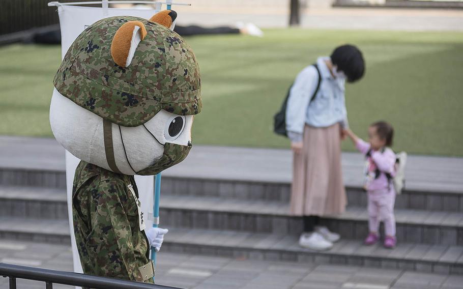 A mascot for the Japan Self-Defense Forces greets commuters outside Fujisawa Station in Kanagawa prefecture, Japan, April 27, 2021. 