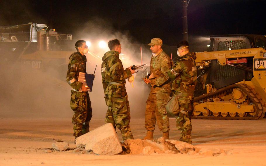 Airmen from the 374th Civil Engineer Squadron survey a crater during training to quickly repair damaged runways, Thursday, May 6, 2021, at Yokota Air Base, Japan. 