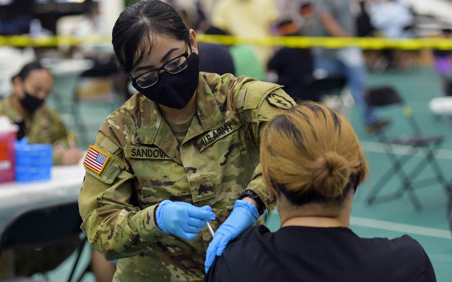 Army Sgt. Diana Sandoval, a combat medic specialist with the 25th Infantry Division, gives a COVID-19 vaccine during a community shot clinic at the University of Guam in Mangilao, April 16, 2021.