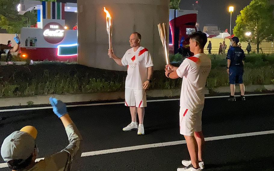 Capt. Brad Stallings, a former Sasebo Naval Base commander who now serves as the U.S. Naval Forces Japan chief of staff, carries the Olympic flame in Sasebo, Japan, Saturday, May 8, 2021. 