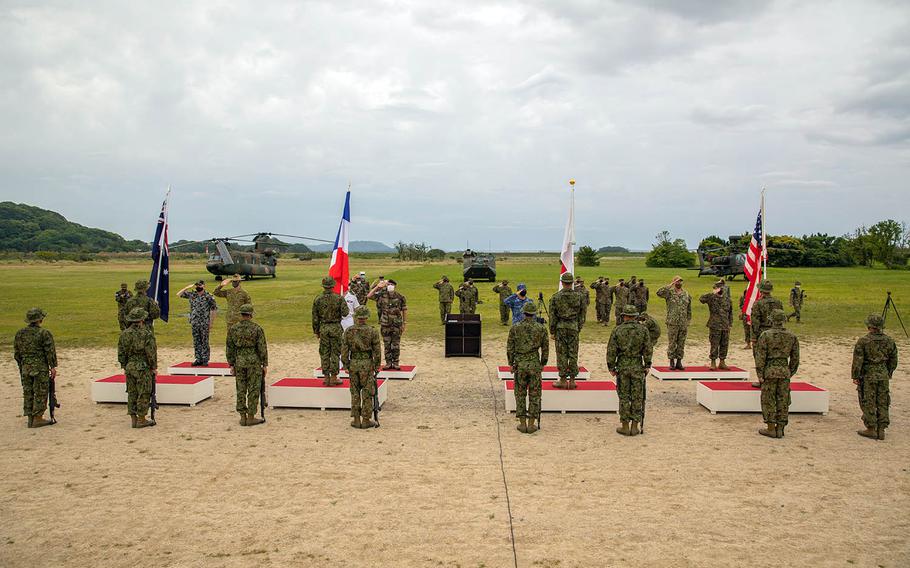 American, Japanese, French and Australian commanders salute their flags during the opening ceremony for exercise Jeanne D'Arc at Camp Ainoura in Sasebo, Japan, Tuesday, May 11, 2021. 