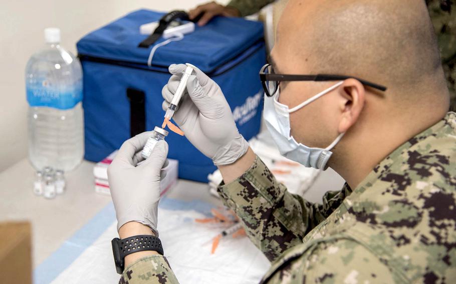 Petty Officer 2nd Class Jose Sabangan prepares a COVID-19 vaccine during a shot clinic at Naval Air Facility Atsugi, Japan, May 7, 2021.