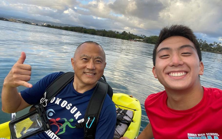 Jonah Lee, a senior at Radford High School, Hawaii, poses with his father, Navy Capt. Benjamin Lee, while kayaking at Pearl Harbor in this undated photo.