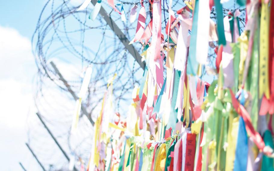 Buddhist prayer ribbons hang from a security fence in Paju, South Korea, near the Demilitarized Zone.