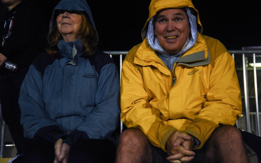 John Taylor, a physical education teacher at Zama American Middle-High School, and his wife, Nancy, brave the wet weather during a game against Matthew C. Perry at Camp Zama, Friday, Oct. 25, 2019.  