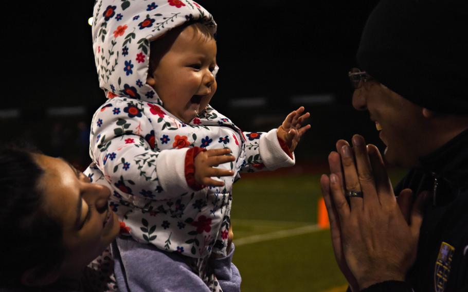 Juan Villalobos plays with his grandchild as Zama American-Middle High School takes on Matthew C. Perry at Camp Zama, Friday, Oct. 25, 2019. 