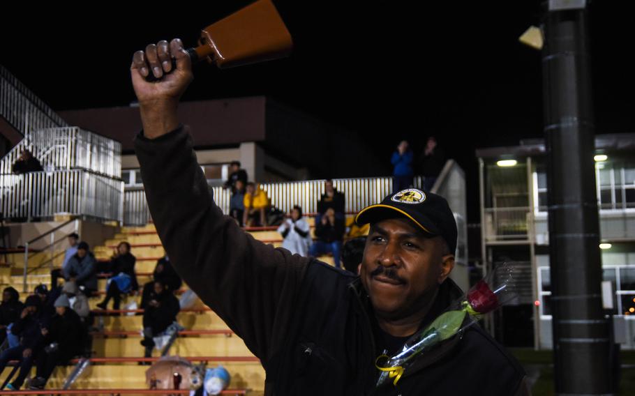 Navy Capt. Lloyd Mack, commanding officer of Naval Air Facility Atsugi, rings a cow bell in support of Zama American Middle-High School during a game against Matthew C. Perry at Camp Zama, Friday, Oct. 25, 2019. 