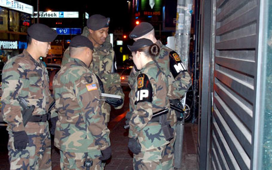 In this 2005 file photo, members of a courtesy patrol for Area II talk with military police officers on a Friday night in Itaewon, a bar district near Yongsan Garrison in Seoul.