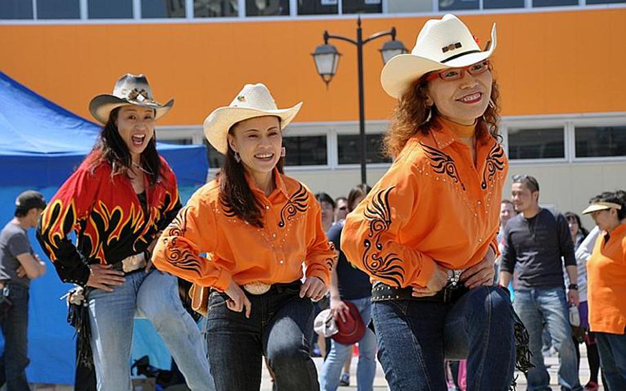 A group of Japanese line-dancers show off their skills during American Day on Sunday, June 6, 2010, outside Misawa Air Base, Japan. About 80,000 people attended the annual festival.