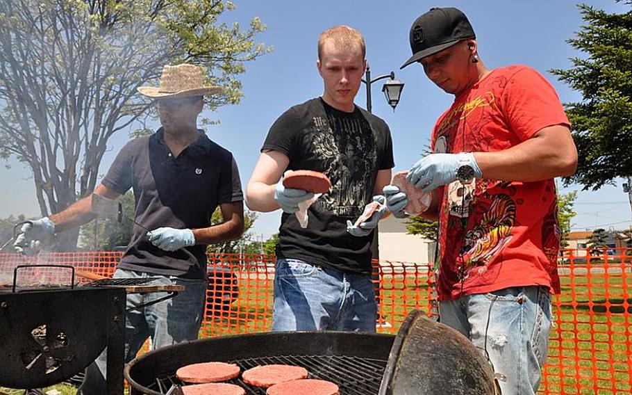 Petty Officer 1st Class Orlando Turnland, right, Petty Officer 2nd Class Joel Gruber, center, and Petty Officer 2nd Class Mario Nunez cook burgers to sell during American Day on Sunday, June 6, 2010, in Misawa City, Japan. About 80,000 people attended the annual festival, which is hosted by the U.S. military at Misawa Air Base.