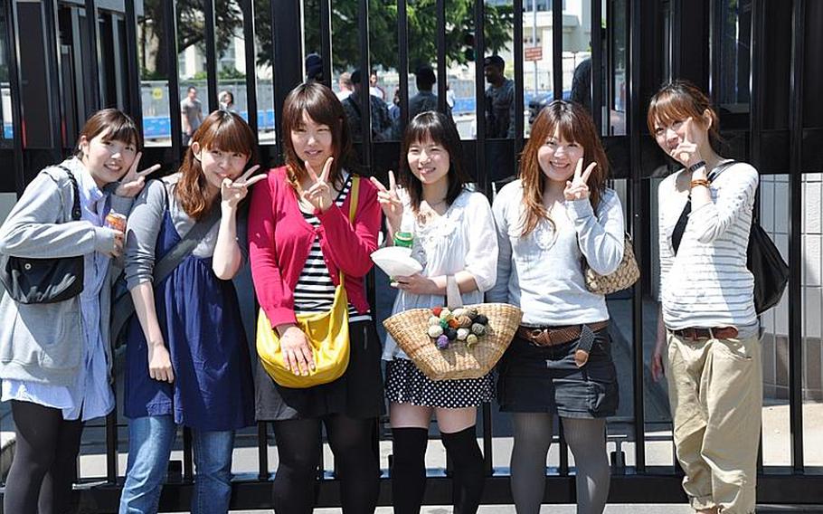 Japanese girls pose for pictures at the front gate of Misawa Air Base, Japan, during the annual American Day celebration on Sunday, June 6, 2010. About 80,000 visitors attended the off-base event, hosted by the U.S. military.