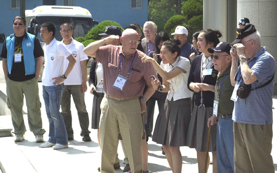 U.S. military veterans of the Korean War, escorted by South Korean school girls, visit the Joint Security Area of Korea&#39;s Demilitarized Zone Thursday. The DMZ was one of many stops the veterans made, who are in South Korea to mark Friday&#39;s 60th anniversary of the start of the Korean War.