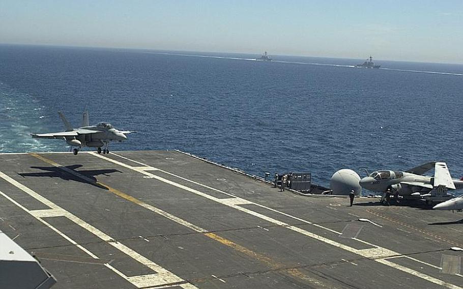 An F-18 Hornet lands on the deck of the USS George Washington on Monday as two warships proceed alongside the aircraft carrier during the Invincible Spirit exercise being staged in the Sea of Japan by the U.S. and South Korea.