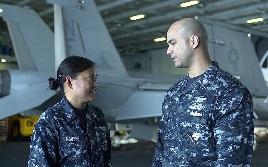 USS George Washington Petty Officer 2nd Class Linhha Nguyen talks to Petty Officer 1st Class Jose Ojeda on Monday aboard the aircraft carrier. Nguyen said the sinking of the South Korean warship Cheonan and the deaths of 46 of its crewmen resonated with U.S. sailors and their families.