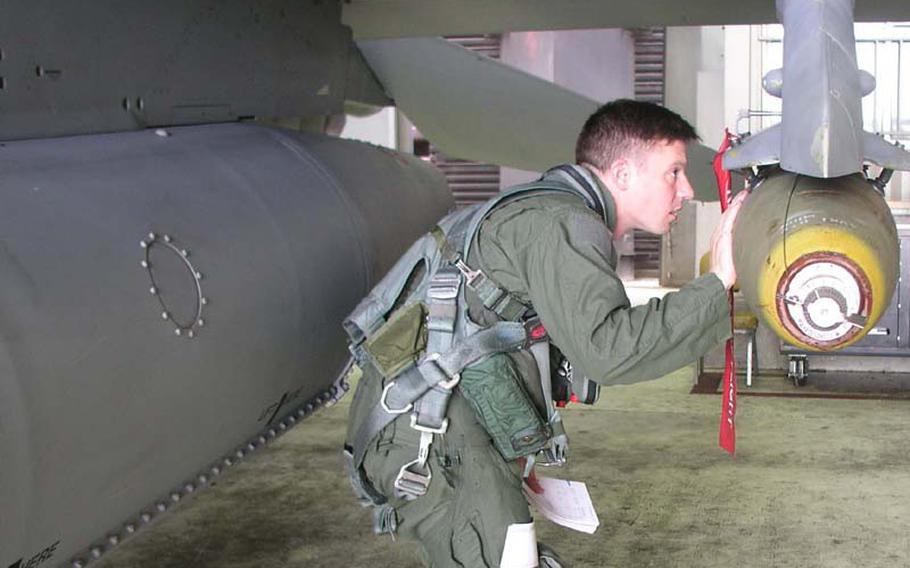 Air Force Capt. Christopher Moeller inspects his F-16C fighter jet Wednesday at Osan Air Base, South Korea, before a combat training mission in which he dropped 500-pound bombs at a training range south of Korea?s Demilitarized Zone. Moeller is with the 36th Fighter Squadron, part of Osan?s 51st Fighter Wing. The mission was one of many combat training sorties flown by U.S. and South Korean aircraft during Invincible Spirit, the four-day exercise that concluded Wednesday night.