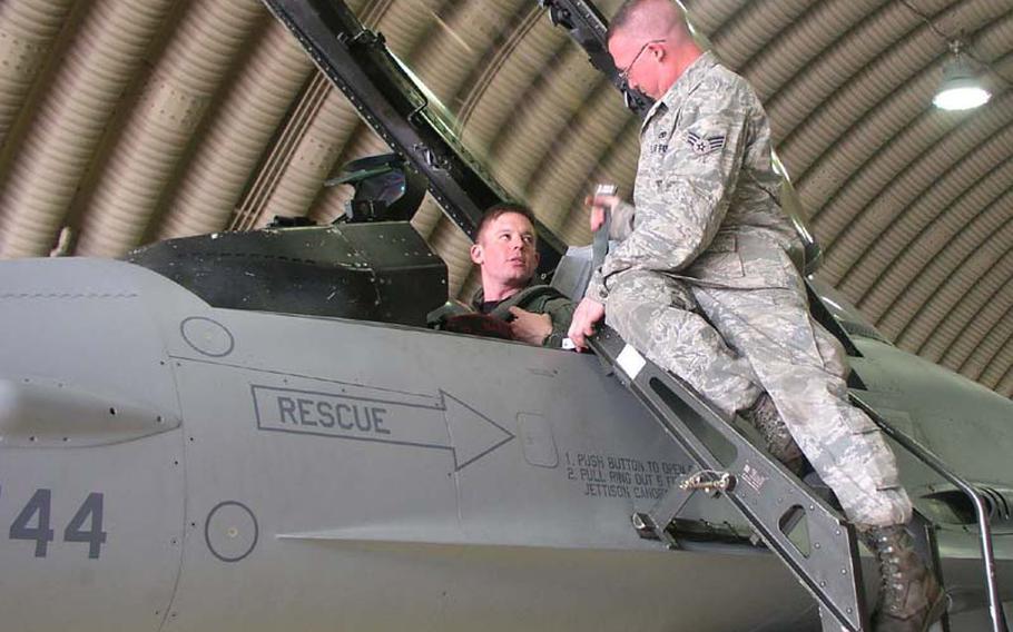 Air Force Capt. Christopher Moeller, left, is assisted by an airman as he settles into the cockpit of his F-16C fighter jet Wednesday at Osan Air Base, South Korea, before a training mission. Moeller was going to drop 500-pound bombs at a training range south of Korea?s Demilitarized Zone as part of the Invincible Spirit exercise.  Moeller is with the 36th Fighter Squadron, part of Osan?s 51st Fighter Wing.