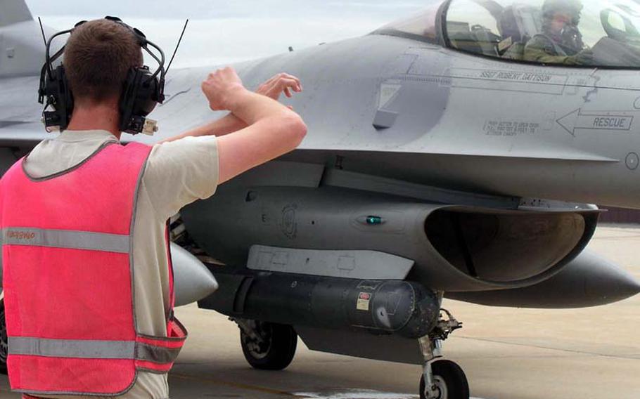 On the flight line at Osan Air Base in South Korea on Wednesday, Air Force Capt. Christopher Moeller at the controls of an F-16C fighter jet follows the signals of an airman before a mission in which he dropped 500-pound bombs at a training range south of Korea?s Demilitarized Zone. Moeller is with the 36th Fighter Squadron, part of Osan?s 51st Fighter Wing. The mission was one of many combat training sorties flown by U.S. and South Korean aircraft during Invincible Spirit, a four-day show of naval and air power. The exercise concluded Wednesday night.