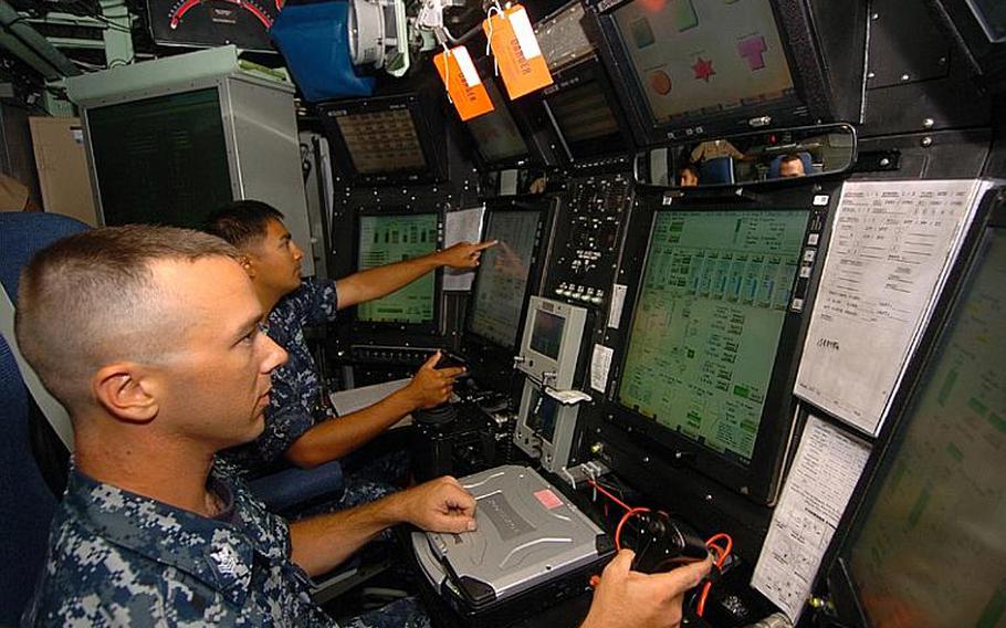 Resembling a cross between a flight cockpit and an iPhone, sailors use touch screens and joysticks to control various aspects of the USS Hawaii while moored at Yokosuka Naval Base on Tuesday. Although sailors can take manual control, the boat can actually drive and stabilize itself, officials said. The visit by the Hawaii is the first by a Virginia class submarine to the 7th Fleet's Western Pacific-based area of operations.