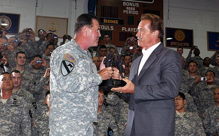 Lt. Gen. Joseph F. Fil Jr., 8th United States Army commander, presents Gov. Arnold Schwarzenegger with a statuette in honor of his visit at Collier Field House at Yongsan Garrison, South Korea, on Wednesday evening.