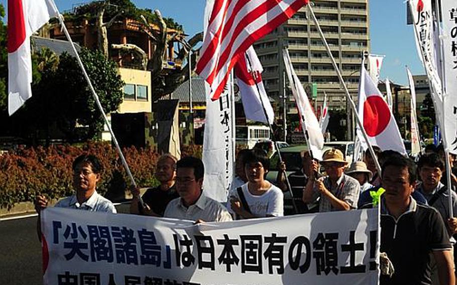 Supporters of U.S. military bases on OKinawa march along Highway 58 in Naha on  Monday. About 250 people attended a rally supporting the U.S.-Japan Secutiry Treaty and objecting top China&#39;s military build-up in the region.