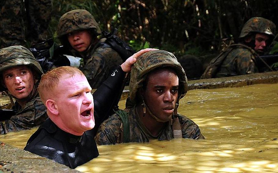 A Jungle Warfare Training Center instructor prepares a Marine for swimming about 15 feet underwater with the aid of a rope.