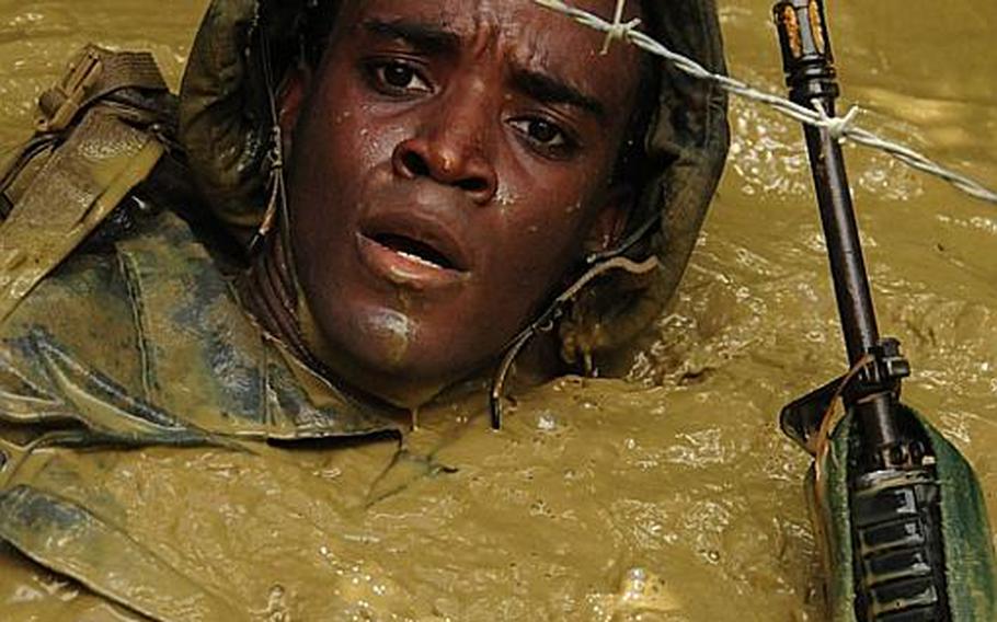 Lance Cpl. Matthew Ito, 20, swims under the barbed wire Thursday at the Jungle Warfare Center on Okinawa.