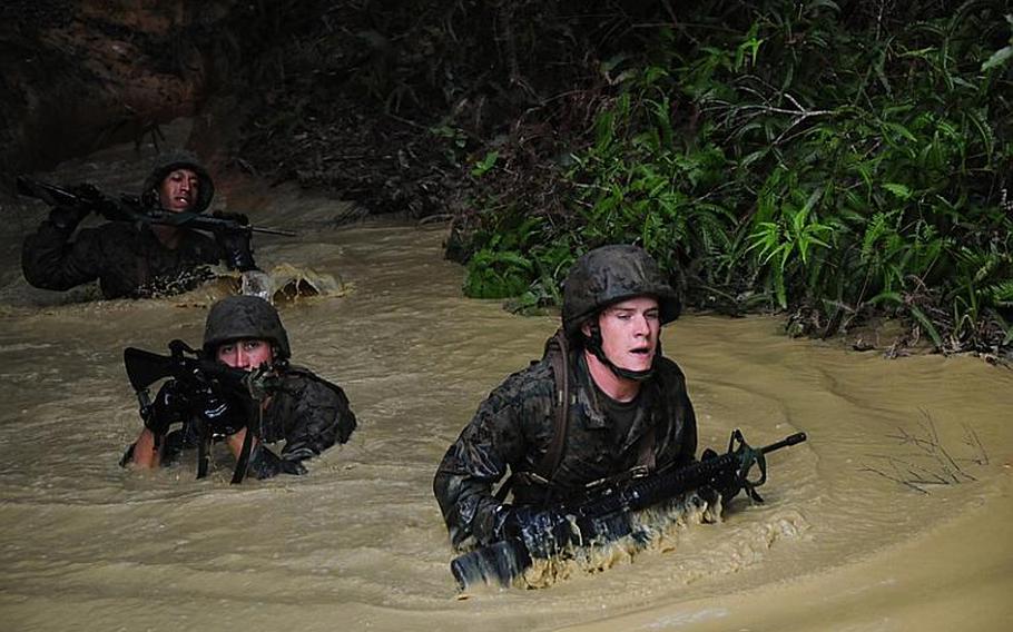 Marines wade through chest-deep water during the endurance course Thursday at the Jungle Warfare Training Center on Okinawa. Each week an average of 80 Marines will complete the course, which is the culmination of weeklong training in jungle warfare.
