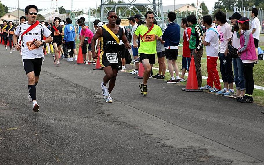 Capt. Darrius Glover, center, a soldier at Camp Zama, runs alongside Japanese civilians at the 21st annual Ekiden relay race Sunday at Sagami General Depot.