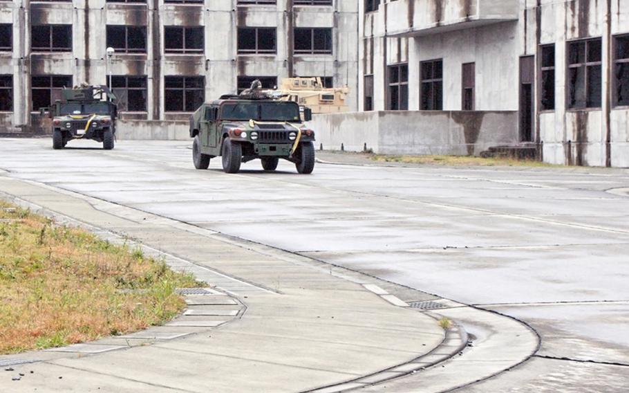 Marines from Company C, 3rd Reconnaissance Battalion, based in Okinawa, roll into a fake town to conduct Military Operations in Urban Terrain at Camp Fuji, Wednesday.