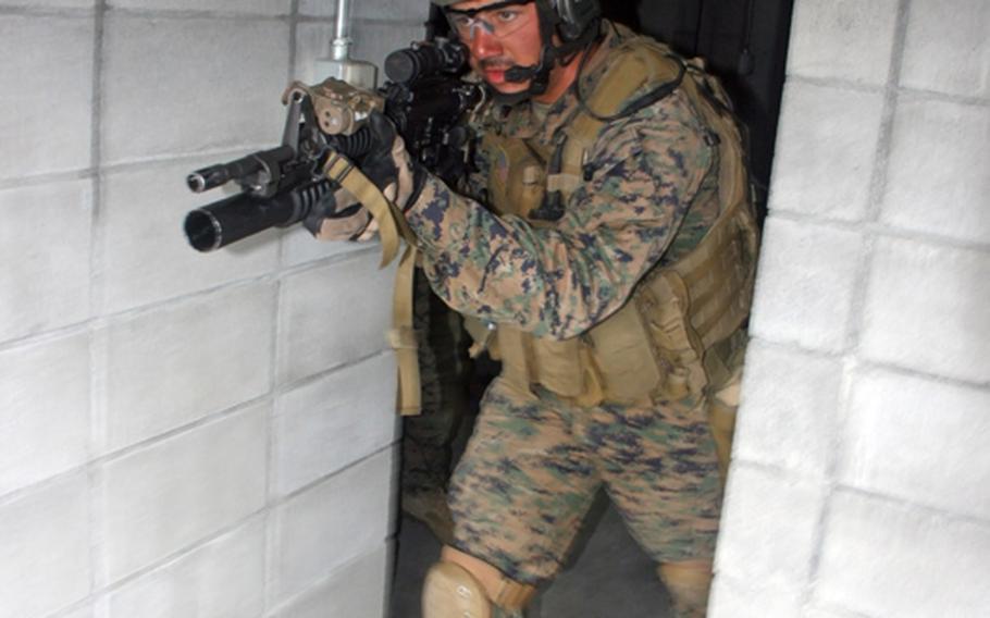 A Marine from Company C, 3rd Reconnaissance Battalion, based in Okinawa, enters a room at the ready as part of the Military Operations in Urban Terrain training at Camp Fuji, Wednesday.