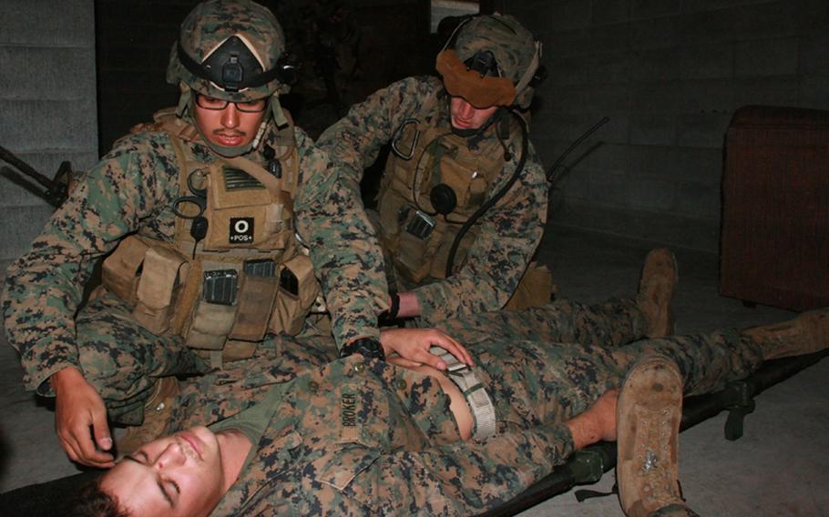 Marines from Company C, 3rd Reconnaissance Battalion, based in Okinawa, tend to an injured member of their team during Military Operations in Urban Terrain training at Camp Fuji, Wednesday.