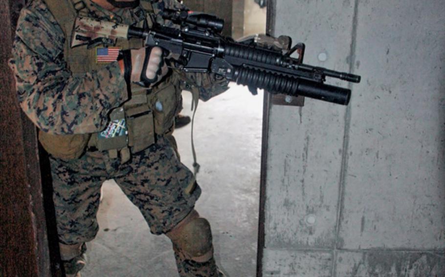 A Marine from Company C, 3rd Reconnaissance Battalion pulls security while his battle buddies clear the room.
