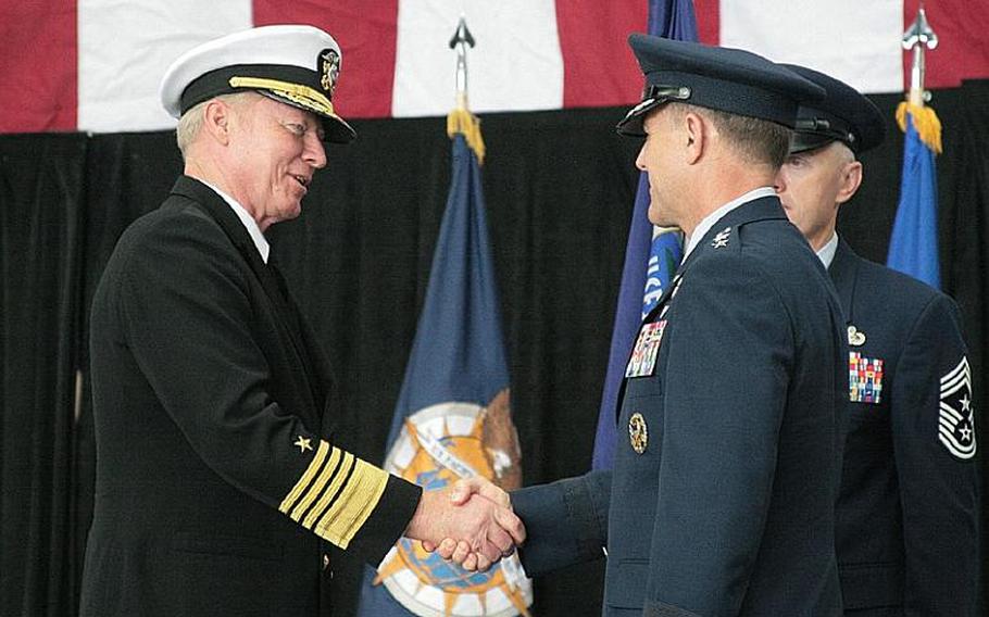 Admiral Robert F. Willard, commander of U.S. Pacific Command, left, congratulates Lt. Gen. Burton Field, who took the reins of U.S. Forces Japan during a change of command ceremony Monday at Yokota Air Base.