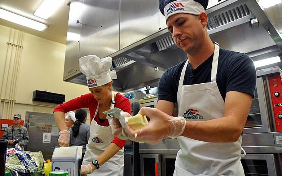 Navy Seaman Rick Longoria and Petty Officer 2nd Class Melissa De La Fuente work on their four-course meal Wednesday during the Iron Chef competition at Misawa Air Base, Japan.