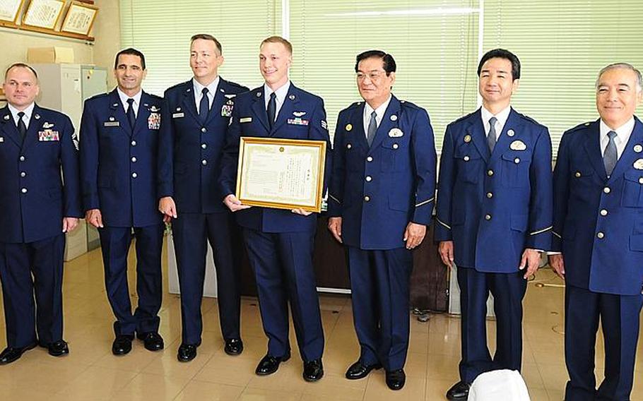 KADENA, Okinawa - Senior Airman Richard Howell, 961st Airborne Air Control Squadron, stands flanked by airmen and Kadena policemen after being presented a Letter of Appreciation Monday for assisting in saving the life of a Japanese Elementary school student from drowning. He was presented the letter from Kadena Police Superintendant Tomomitsu Higa.