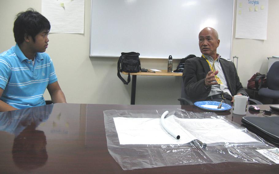 Yuichi Mori, right, explains his hydrogel-based system of growing plants to Yokosuka Middle School 8th-grader Christian Parros, 14, Thursday at the school. School officials hope to use the technology to teach students about nutrition and agriculture.